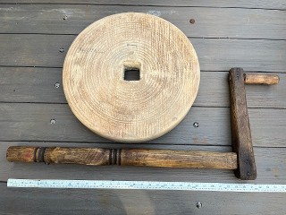 Antique 18-inch by 2 1/2-inch square holed grinding wheel with wood shaft, 50 lbs.