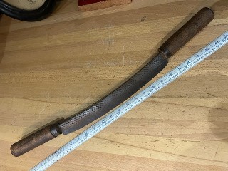 Antique hand forged out of a rasp file drawknife log peeler, with a 13-inch blade, about 24-inch long with handles. Antique hand forged out of a rasp file drawknife log peeler, with a 13-inch blade, about 24-inch long with handles.