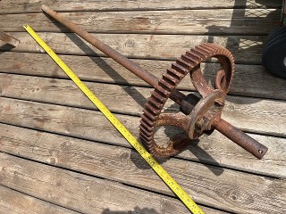 Antique solid steel axle 1.460 diameter by 55-inches long with a 15-inch diameter spoked gear.
